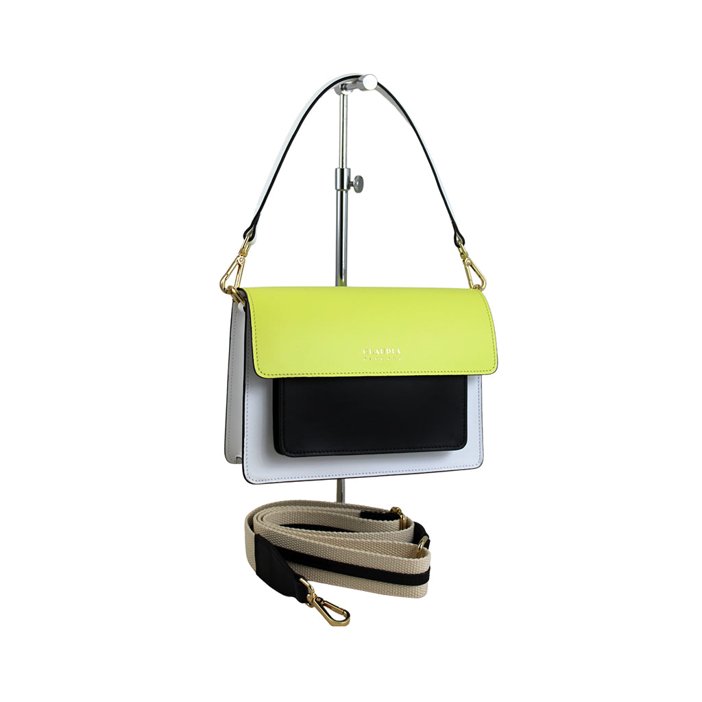 Yellow, black, and white color block handbag on display stand with detachable strap
