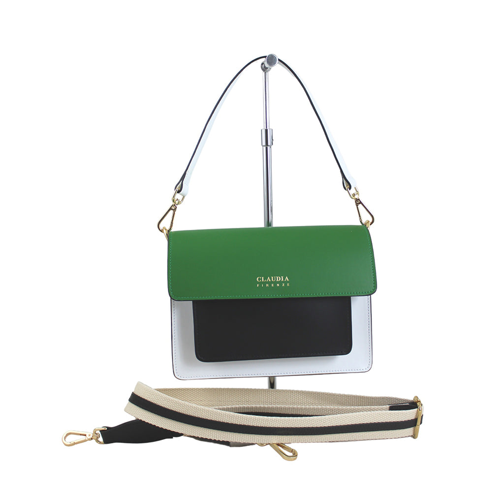 Green, white, and black crossbody handbag with adjustable strap on a display stand