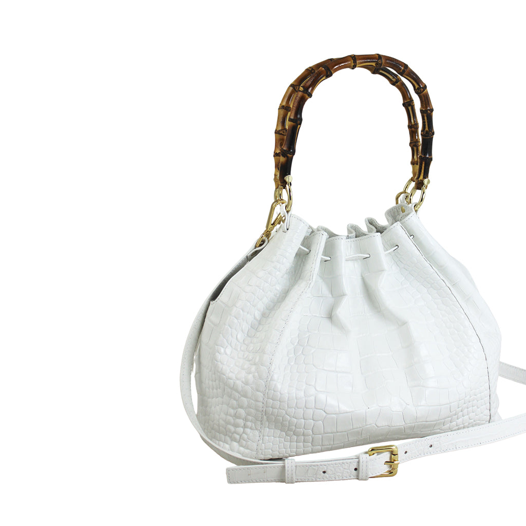 White crocodile-textured handbag with bamboo handle and adjustable strap