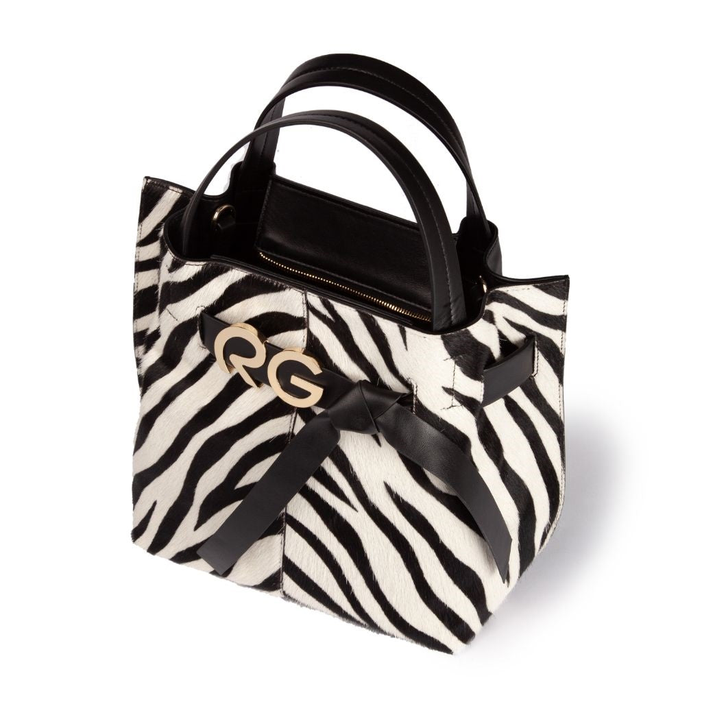 Zebra print handbag with black leather handles and gold clasp