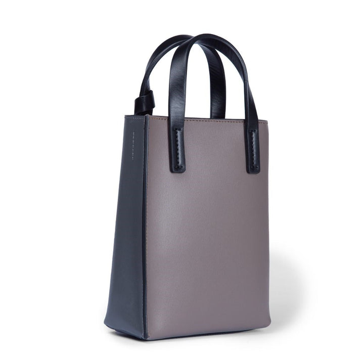 Stylish two-tone leather tote bag with black and grey panels and black handles