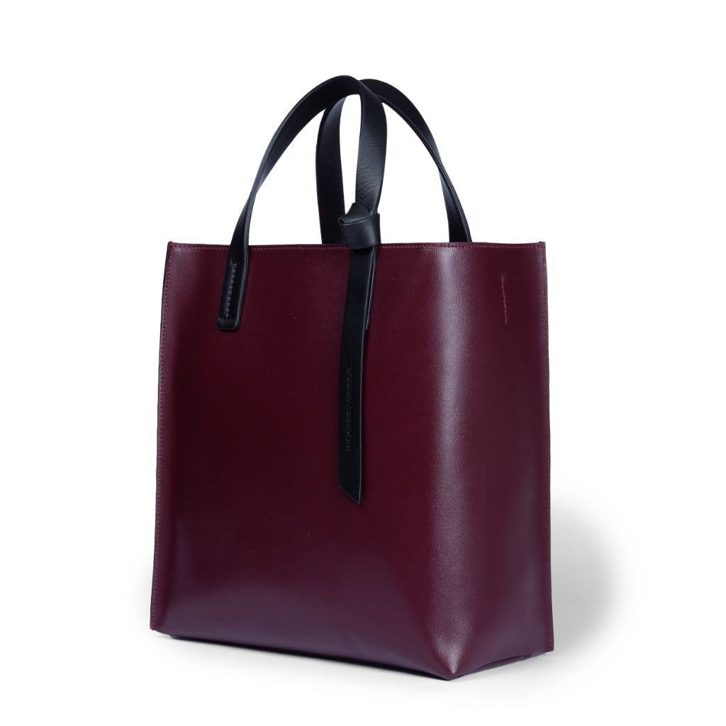 Elegant burgundy leather tote bag with black straps