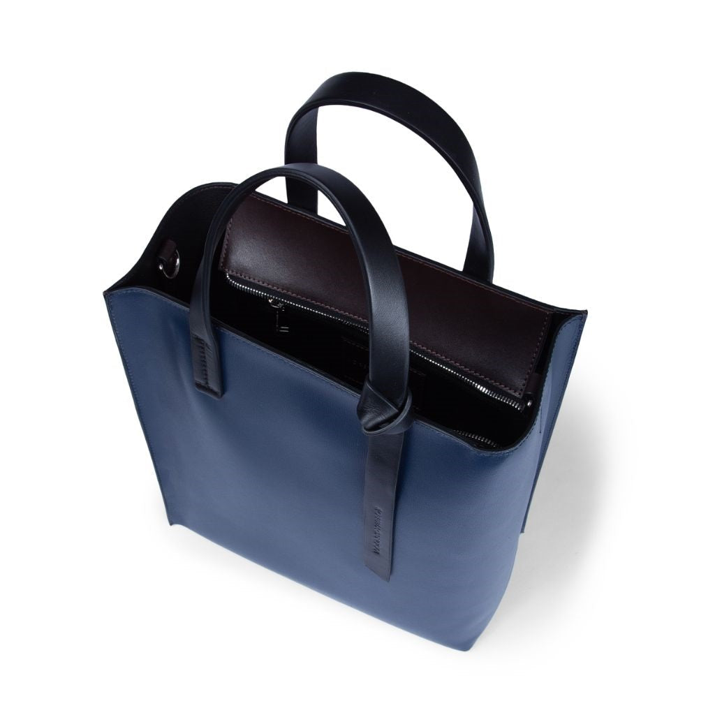 Elegant navy blue leather tote bag with black handles and zipper compartment