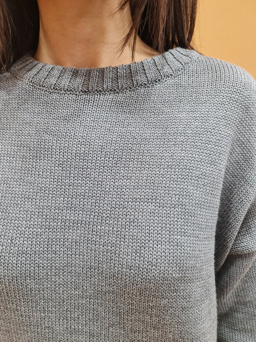 Close-up of a woman wearing a gray knitted sweater