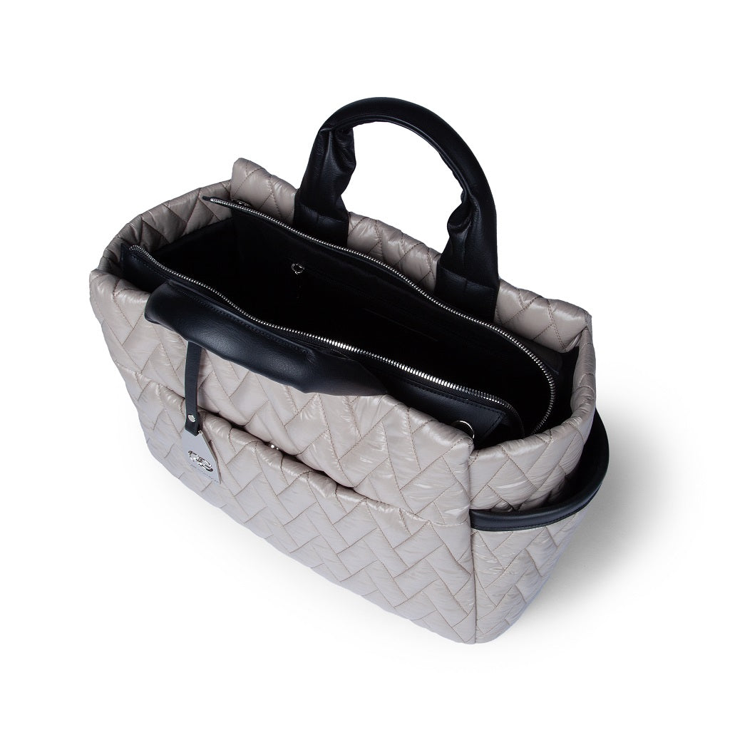 Quilted beige handbag with black leather handles and multiple compartments