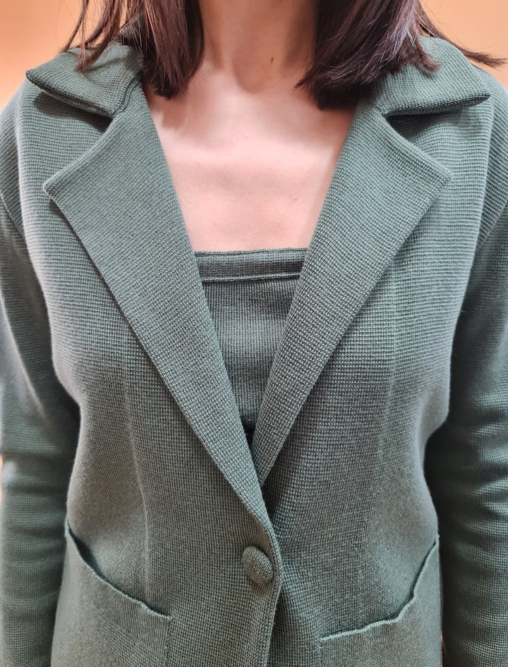 Woman wearing a green knit blazer and matching top