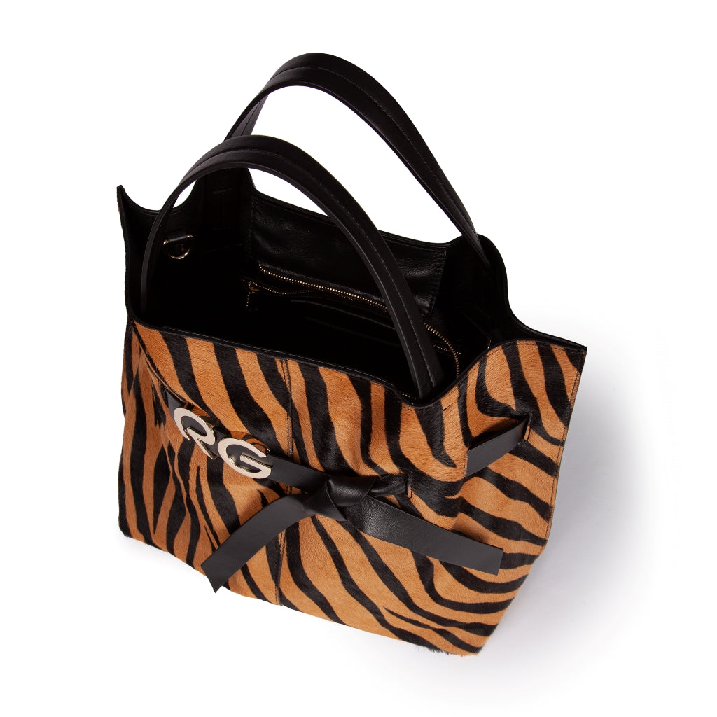 Tiger print leather handbag with black handles and decorative bow