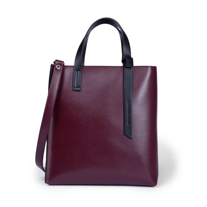 Burgundy leather tote bag with black handles and detachable shoulder strap