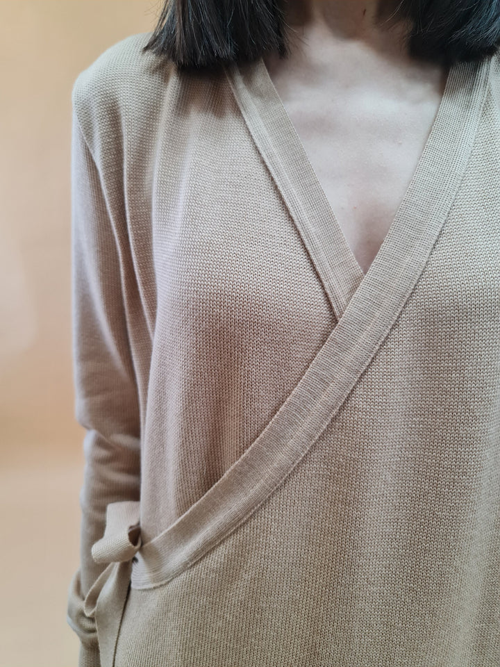 Close-up of woman wearing a beige wrap cardigan