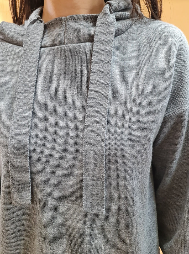 Close-up of a person wearing a gray knit hoodie