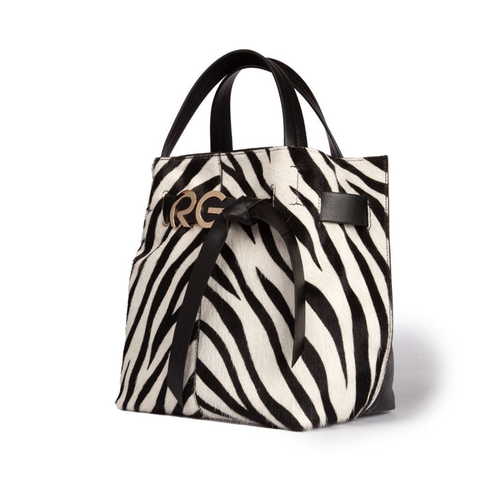 Stylish black and white zebra print handbag with black handles and a bow accent