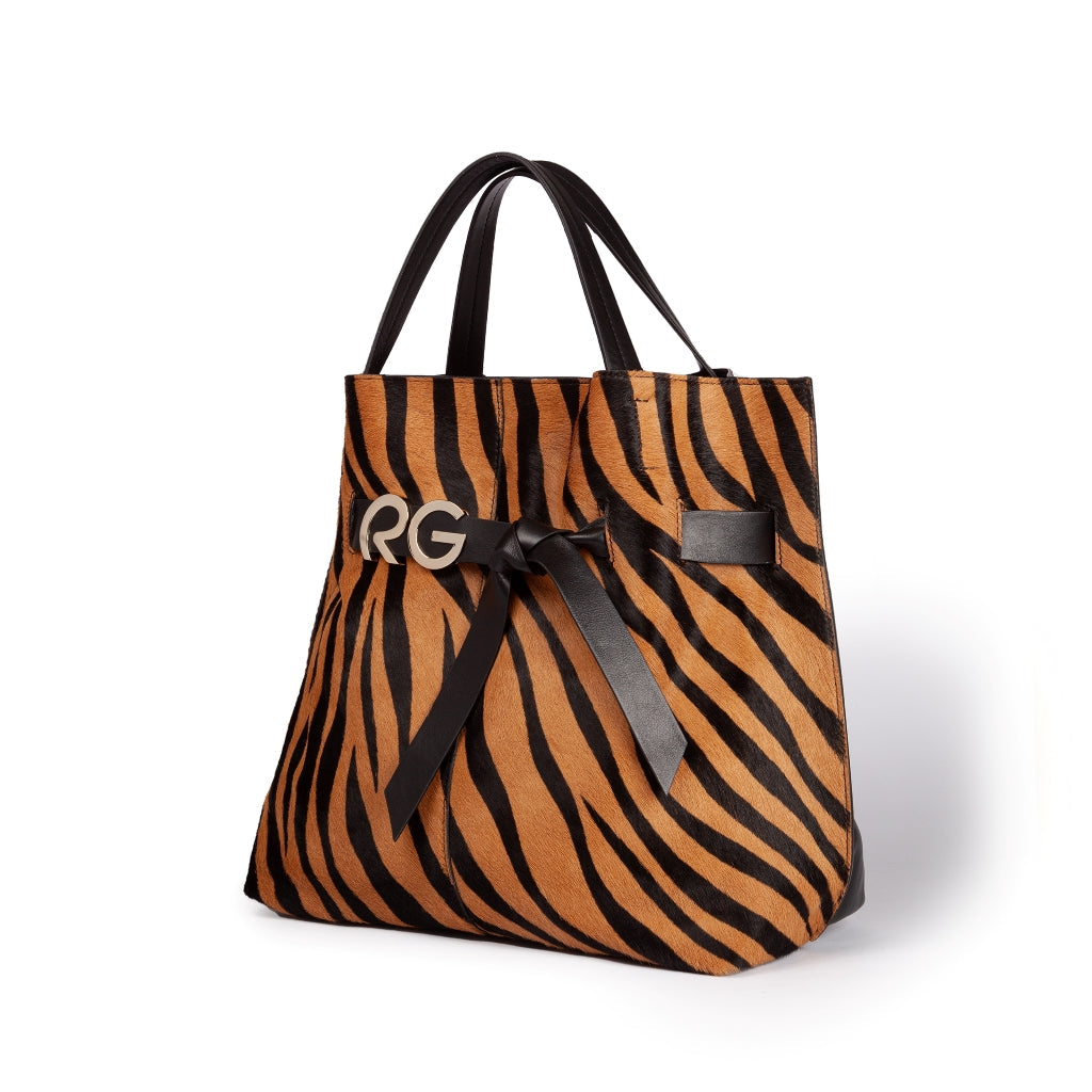 Stylish tiger print tote bag with black handles and ribbon