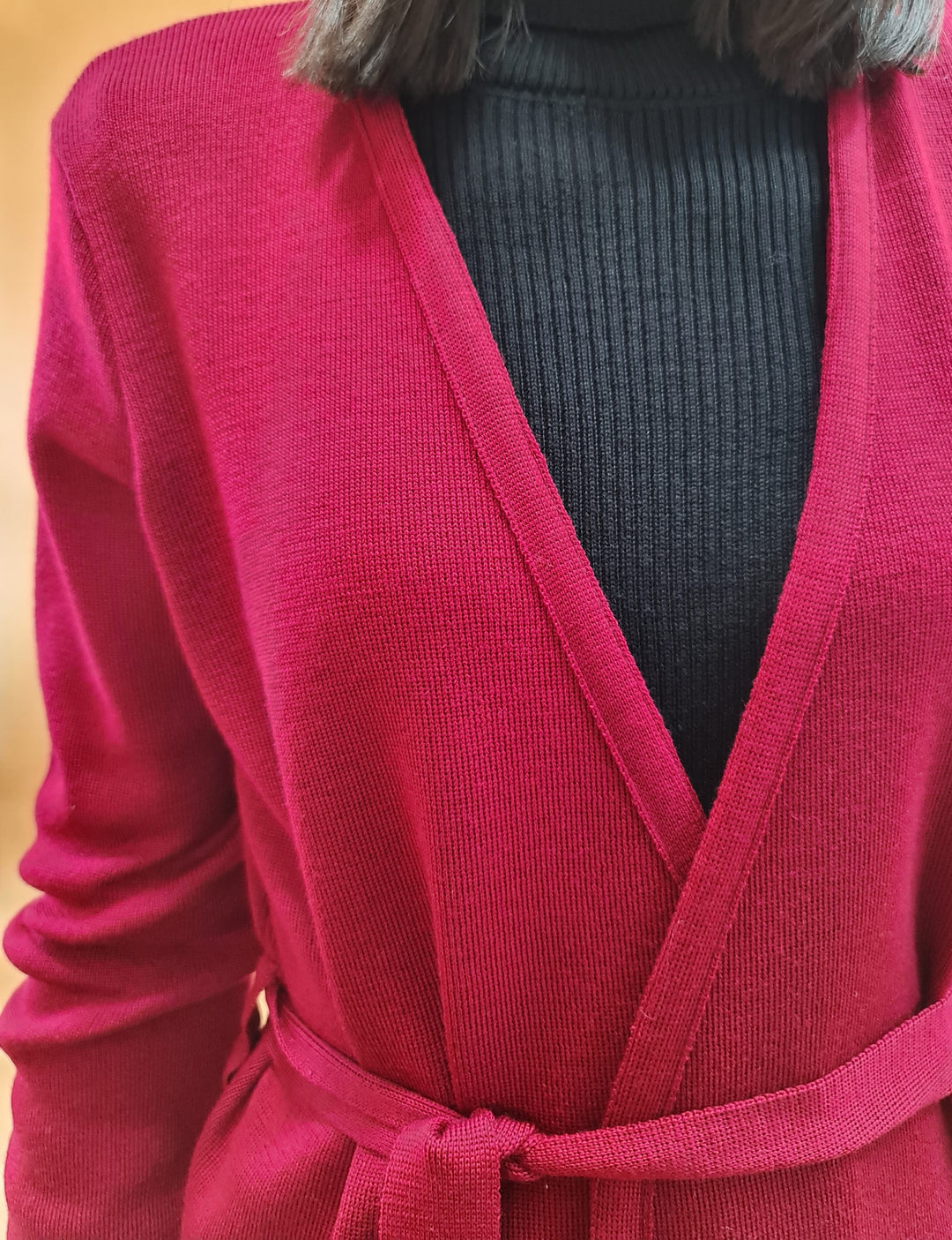 Close-up of person wearing a red cardigan over a black ribbed turtleneck