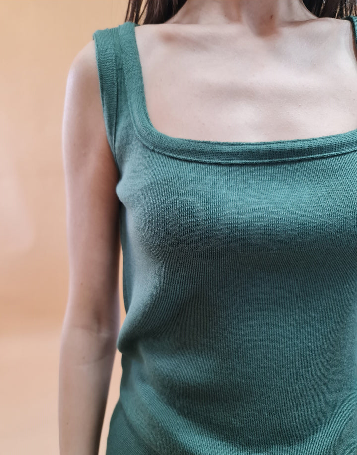 Woman wearing a green sleeveless knit top