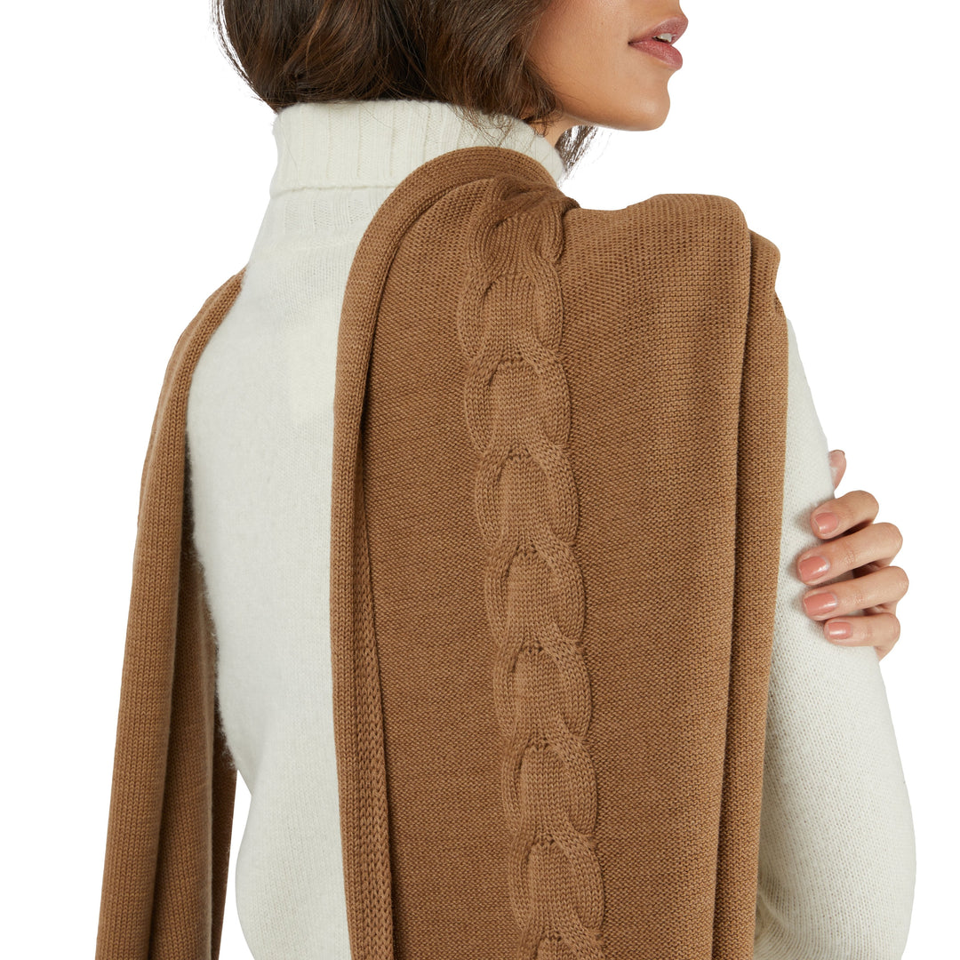 Woman in a white turtleneck wearing a stylish brown knit scarf with a cable pattern