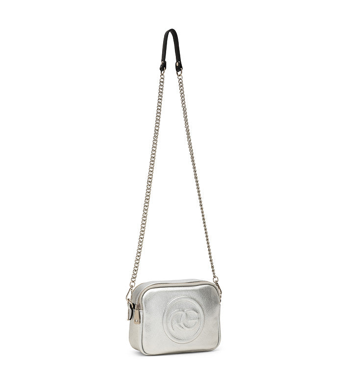 Silver crossbody bag with gold chain strap and circular logo on the front