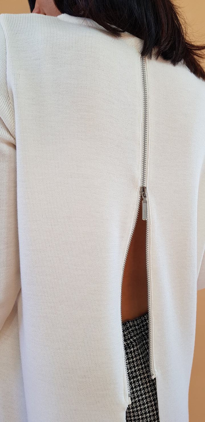 Back view of a white sweater with a silver zipper detail