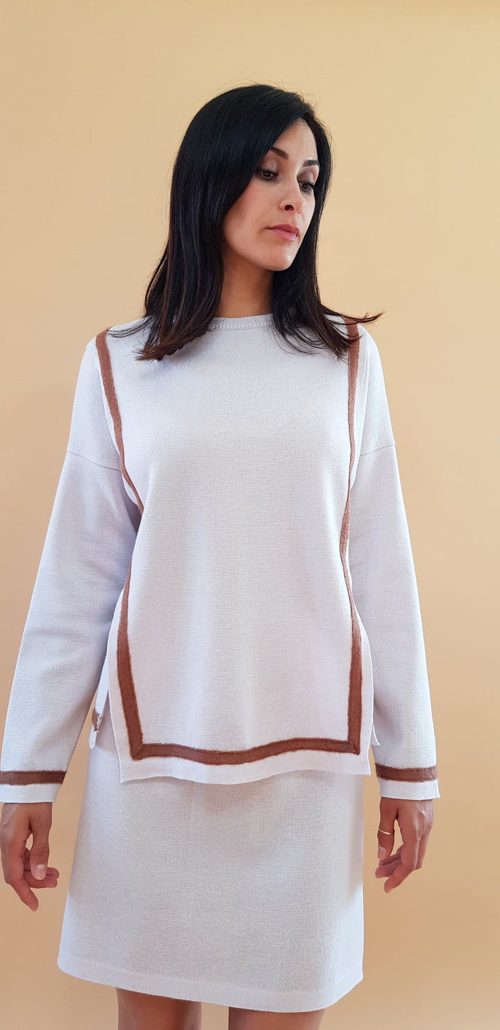 Woman wearing white and brown long-sleeve top with matching skirt