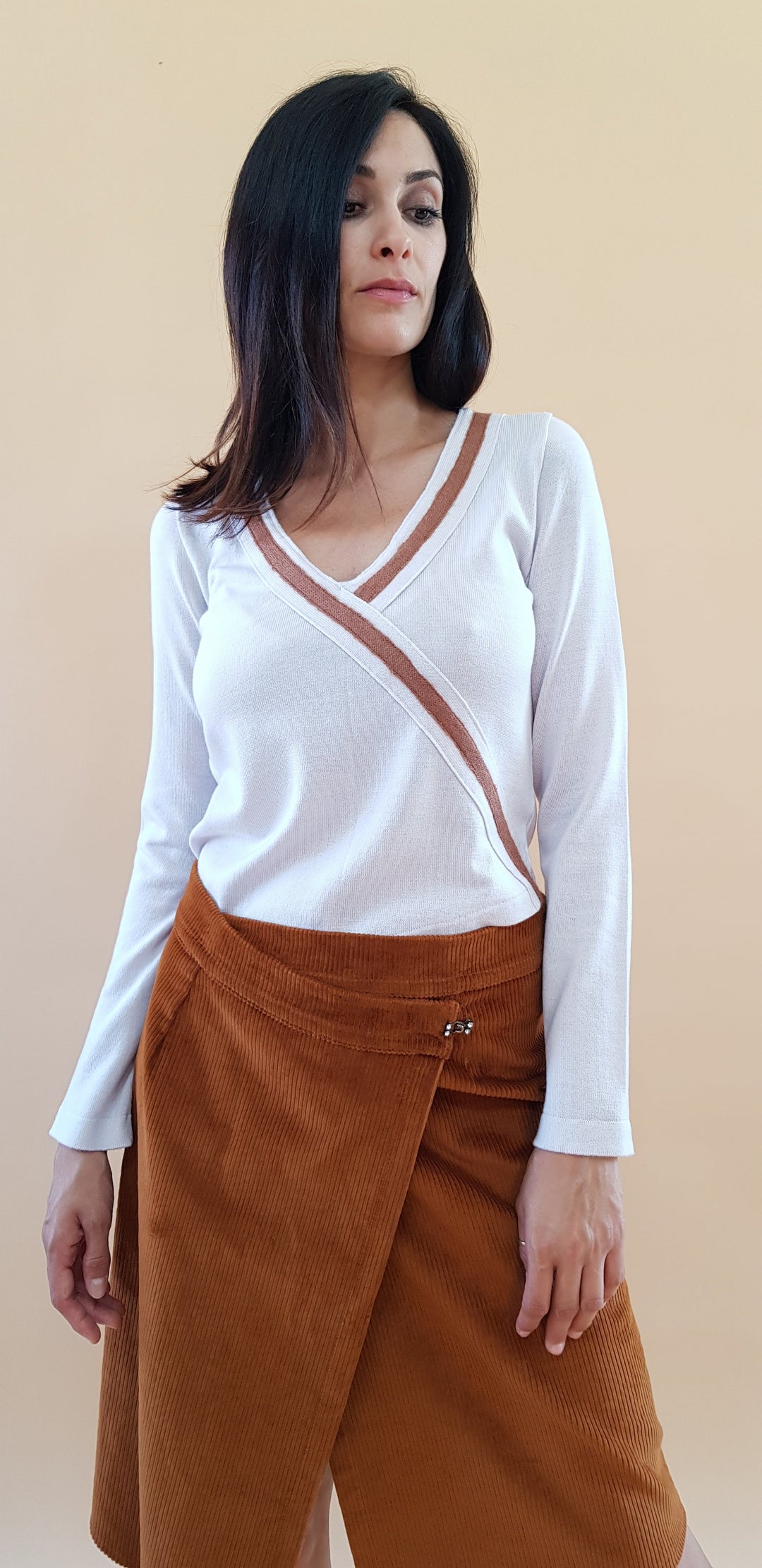 Woman in white long sleeve top and brown skirt