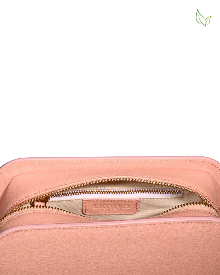 Peach-colored leather bag with zipper partially opened