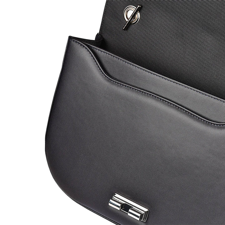 Close-up of an elegant black leather handbag with a sleek clasp opening