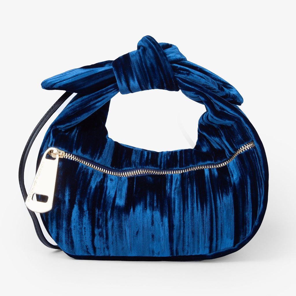 Blue velvet handbag with gold zipper and tied handle