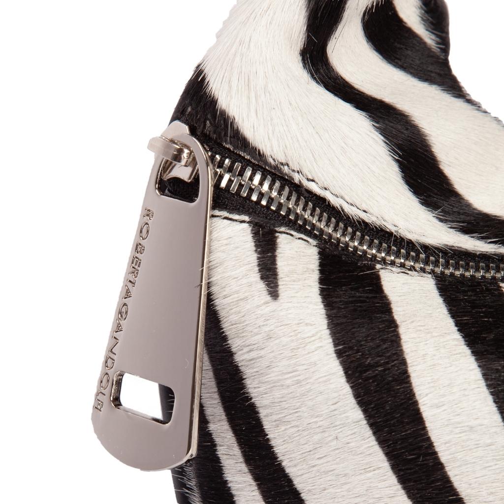 Close-up of zebra print handbag with metallic zipper and branded zipper pull