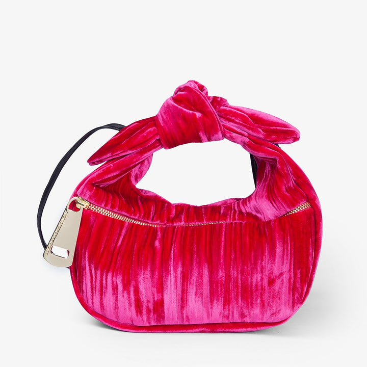 Hot pink velvet handbag with gold zipper and decorative knot handle