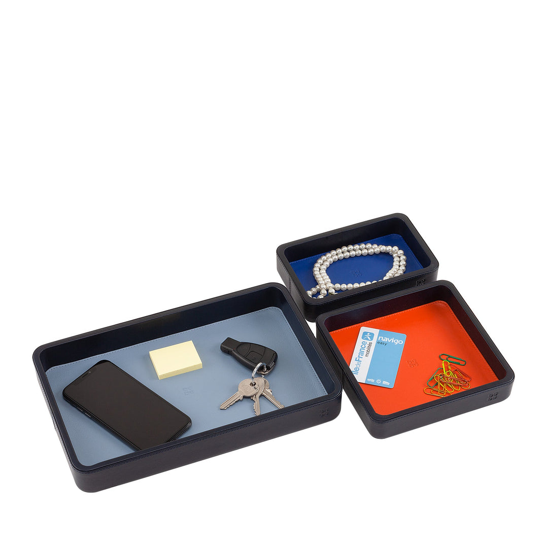 Three rectangular organizational trays with assorted items such as keys, phone, pearls, paperclips, and sticky notes