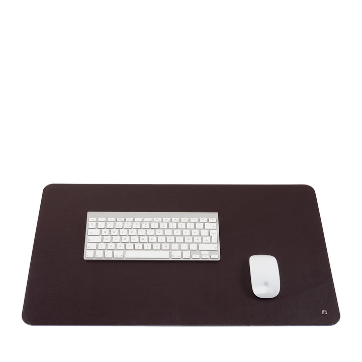 Minimalistic workspace setup with white keyboard and mouse on a dark brown desk pad