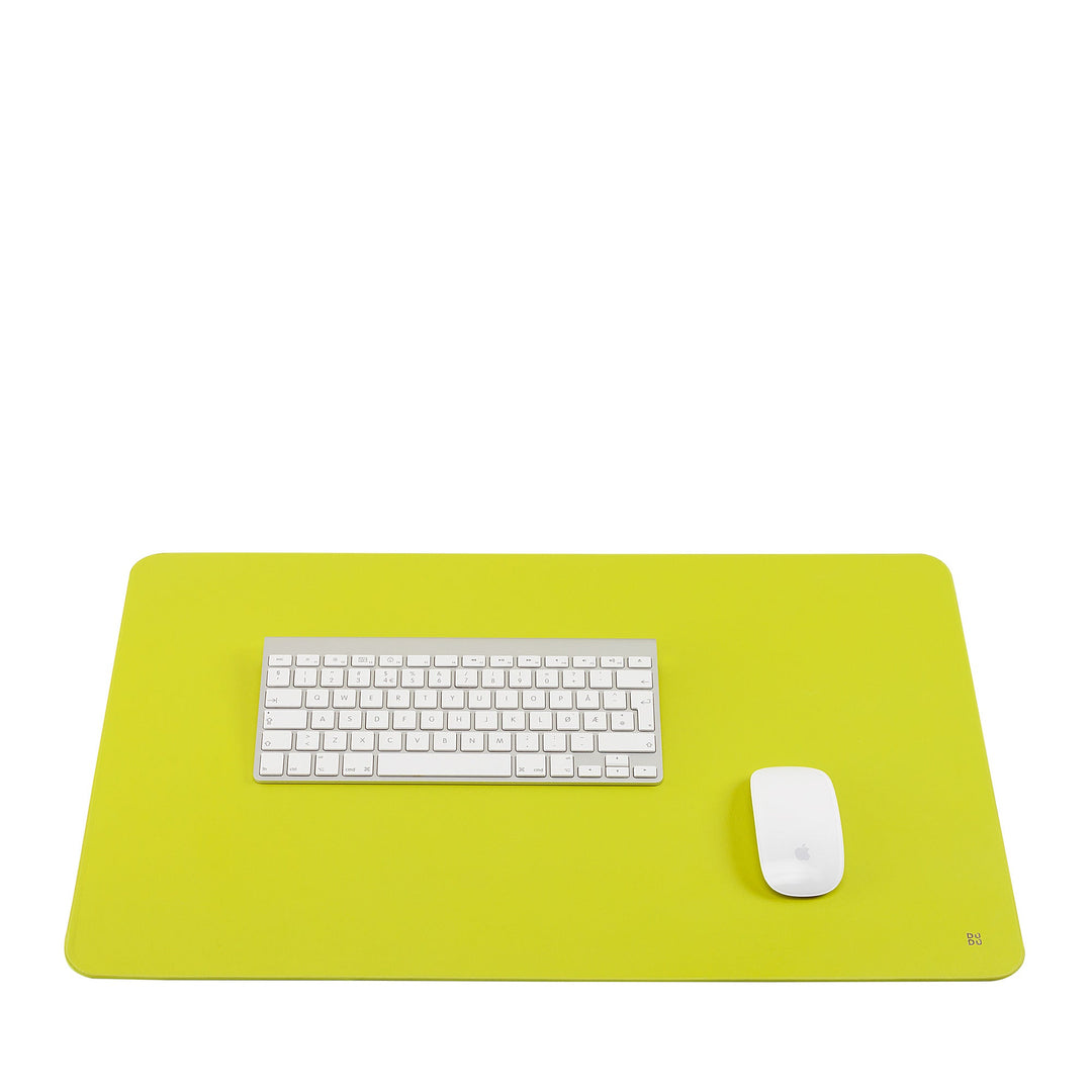 Minimalist workspace with green desk mat, white keyboard, and mouse