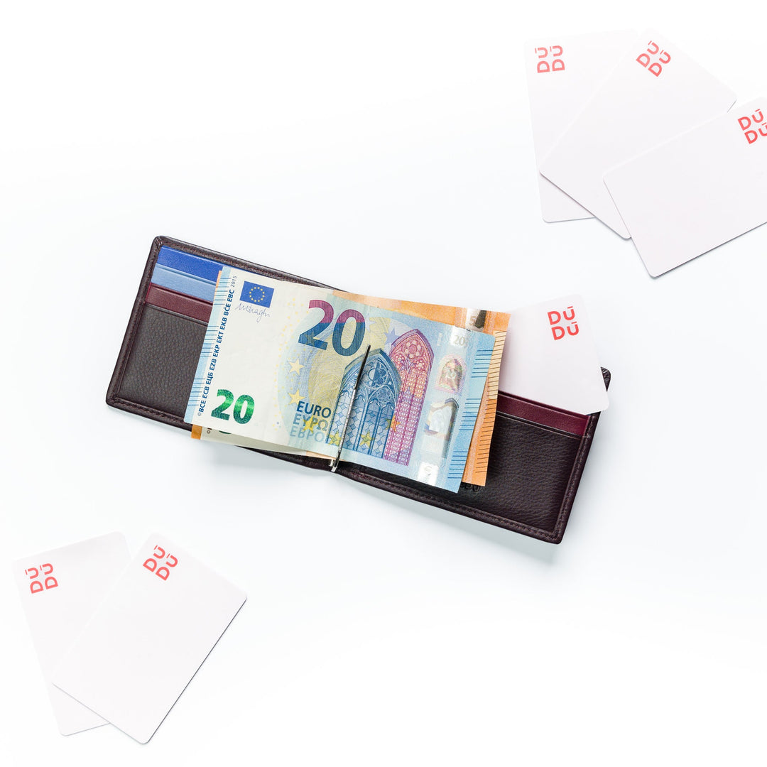 Open wallet with 20 euro bills and scattered blank cards