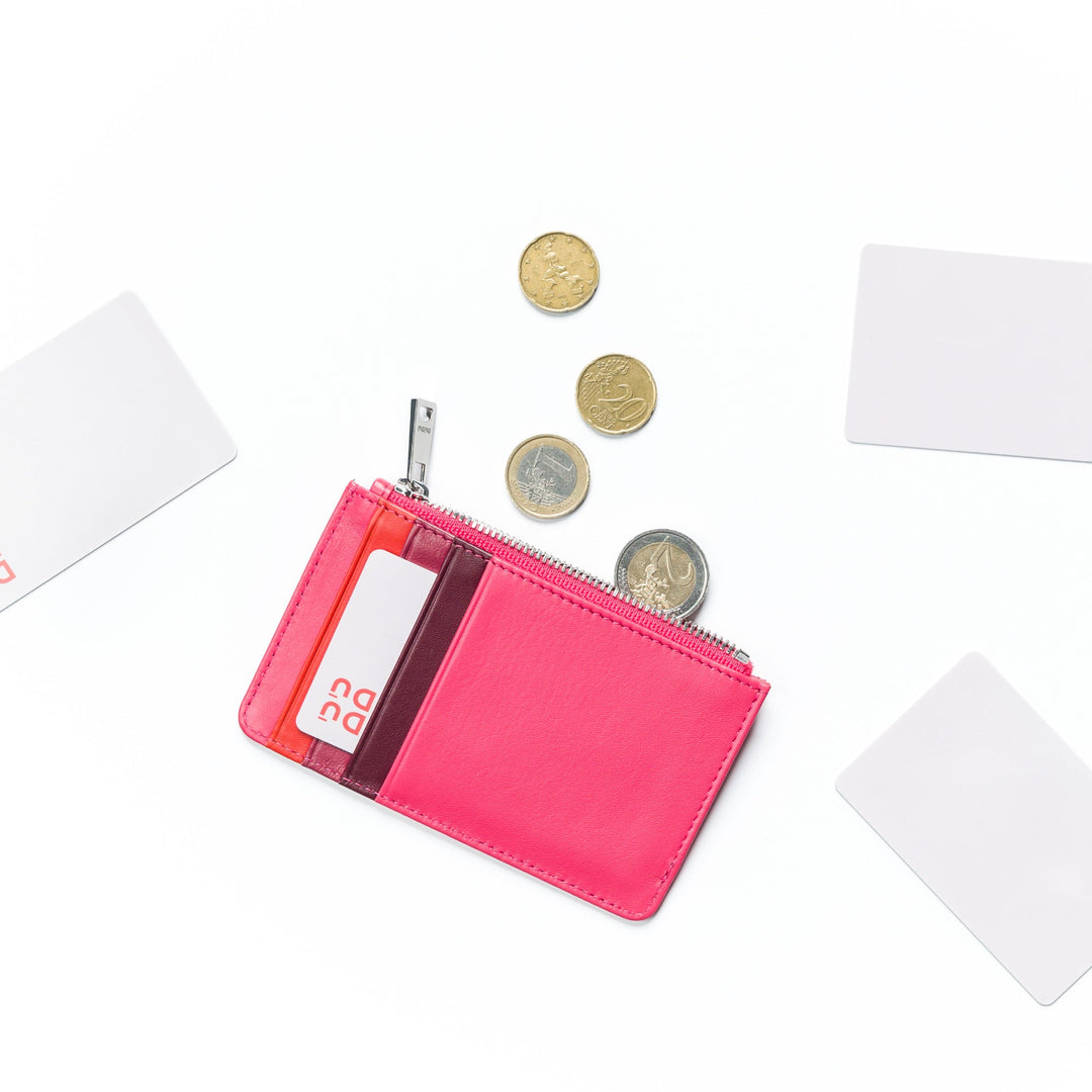 Pink wallet with credit cards and various coins