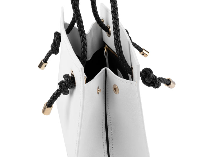 White leather handbag with black braided drawstring closure and gold accents
