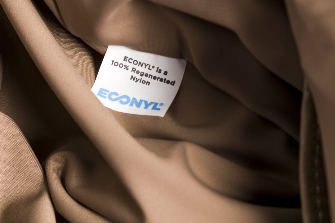 Close-up of clothing label showing ECONYL 100% regenerated nylon fabric