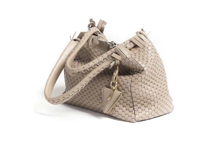 Woven beige leather handbag with braided handles and a decorative tag.