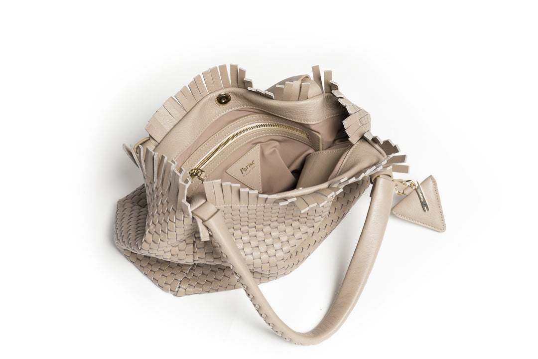 Woven beige leather handbag with braided handles and a decorative tag.