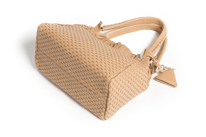 Elegant tan woven leather handbag with tassel accents on white background.