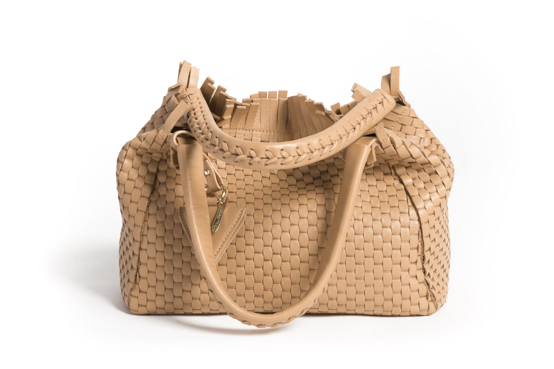 Elegant tan woven leather handbag with tassel accents on white background.