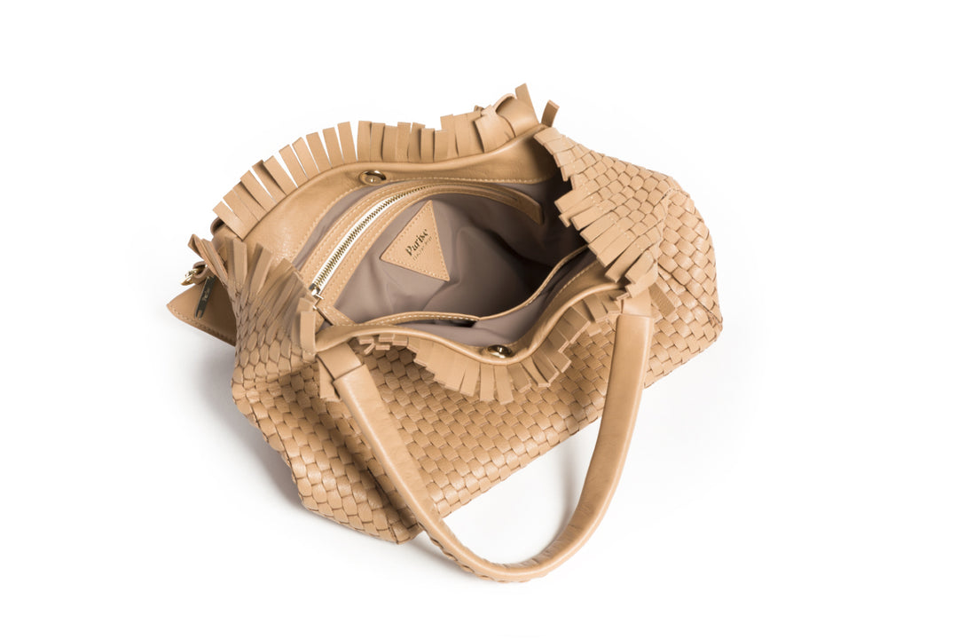 Elegant tan woven leather handbag with tassel accents on white background.