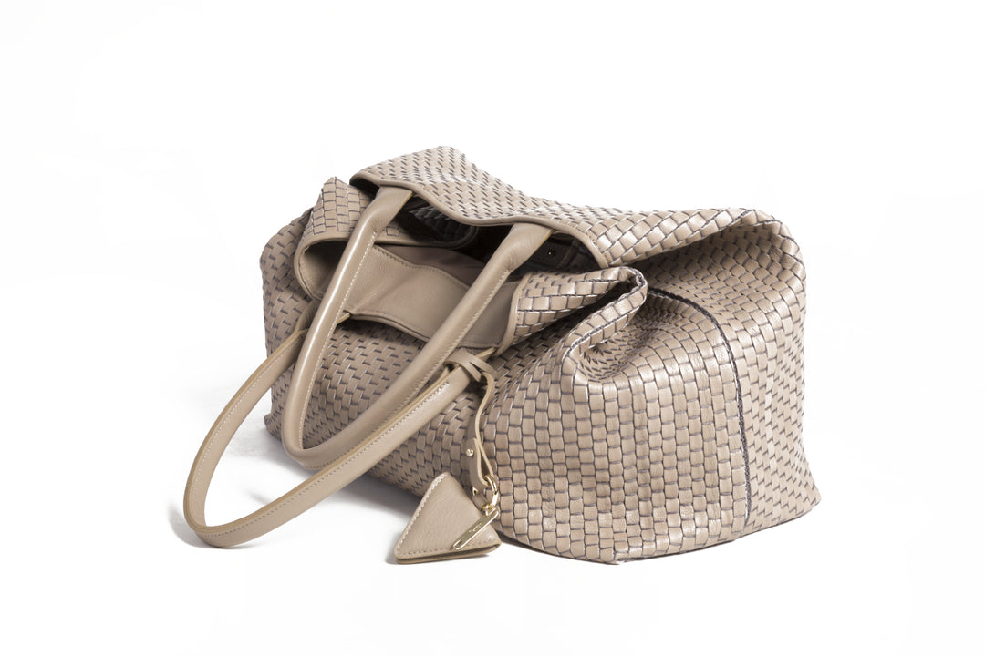 Elegant beige woven tote bag on white background.