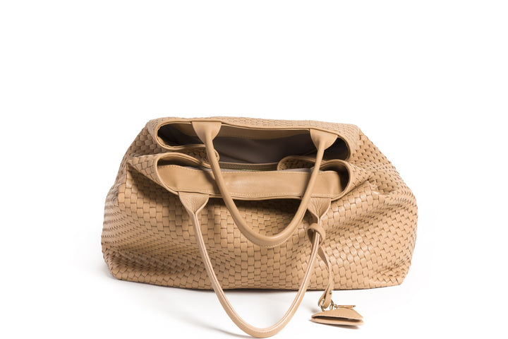 Handcrafted beige woven leather tote bag with dual handles and a triangular charm.