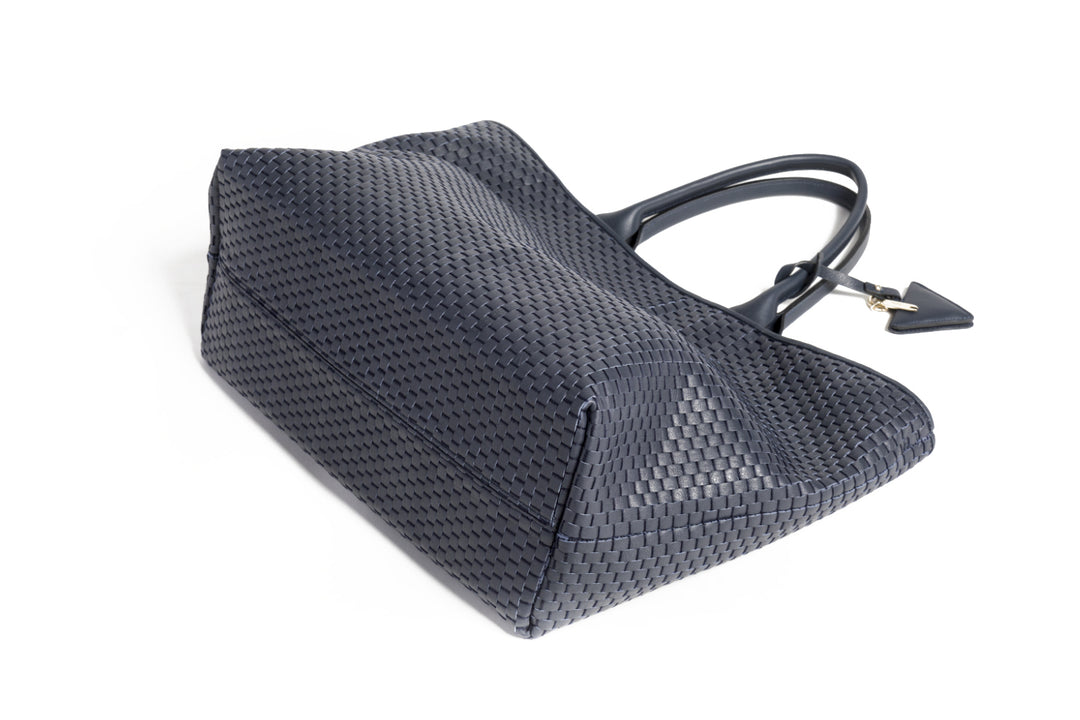 Elegant black woven tote bag with leather straps and decorative tag.