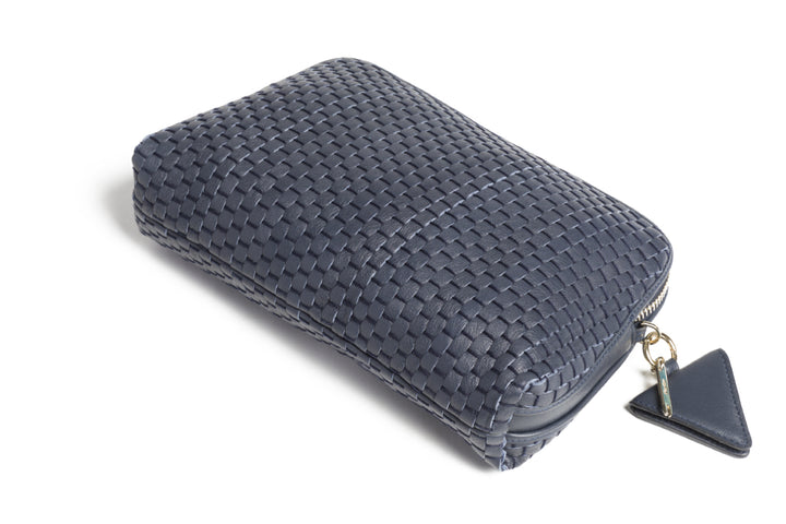 Dark blue woven leather handbag with shoulder strap and zipper closure against white background.