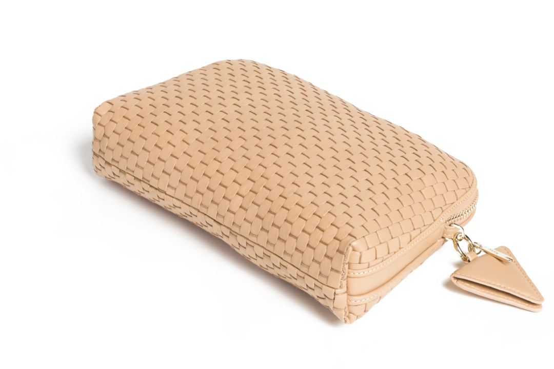 Tan woven leather handbag with shoulder strap on white background.