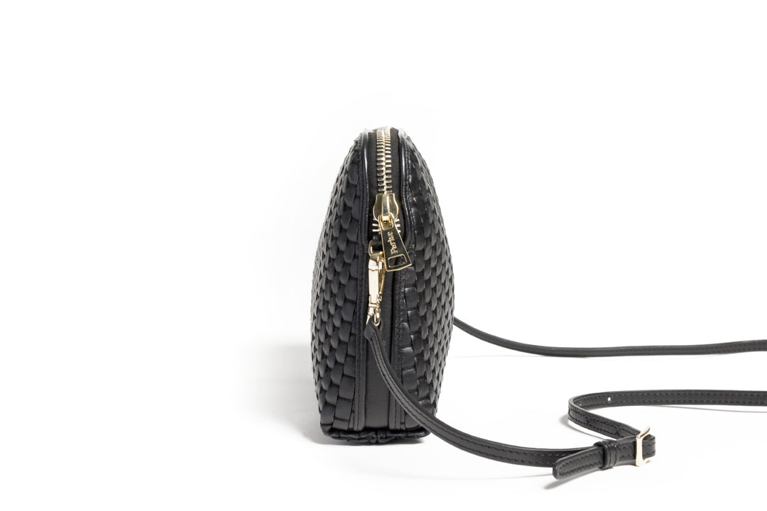 Black woven leather handbag with top handle and detachable shoulder strap on white background.