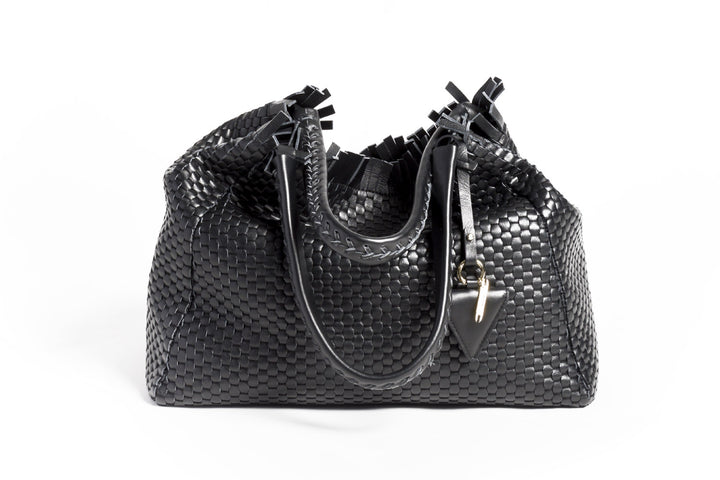 Black woven leather handbag with triangle pendant on white background.