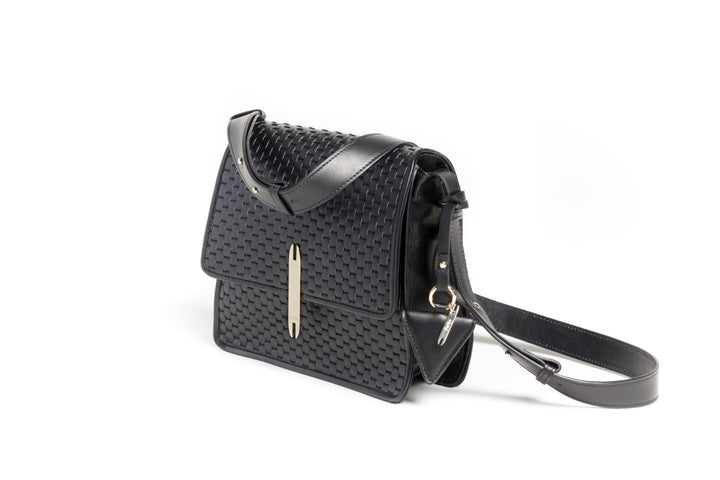 Black woven leather handbag with shoulder strap on white background.