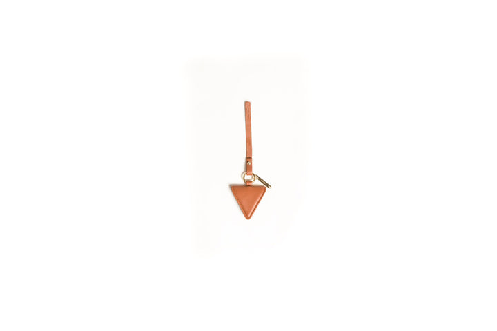 Triangular brown leather keychain with strap and metal ring on white background.