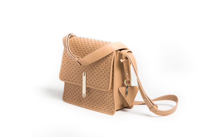 Tan woven leather crossbody bag with gold clasp and adjustable strap on white background.